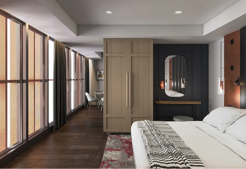 Modern bedroom with a large bed, patterned throw, wooden wardrobe, dark accent wall with vanity mirror, and chairs near tall windows with curtains.