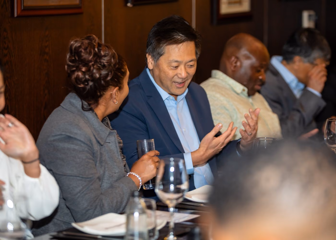 Executives sharing a laugh around a PeerRoom roundtable