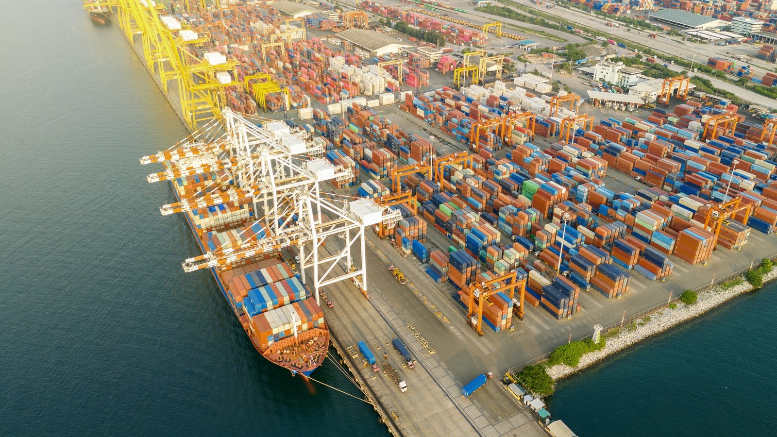 Aerial view of a container terminal with gantry cranes and a moored vessel