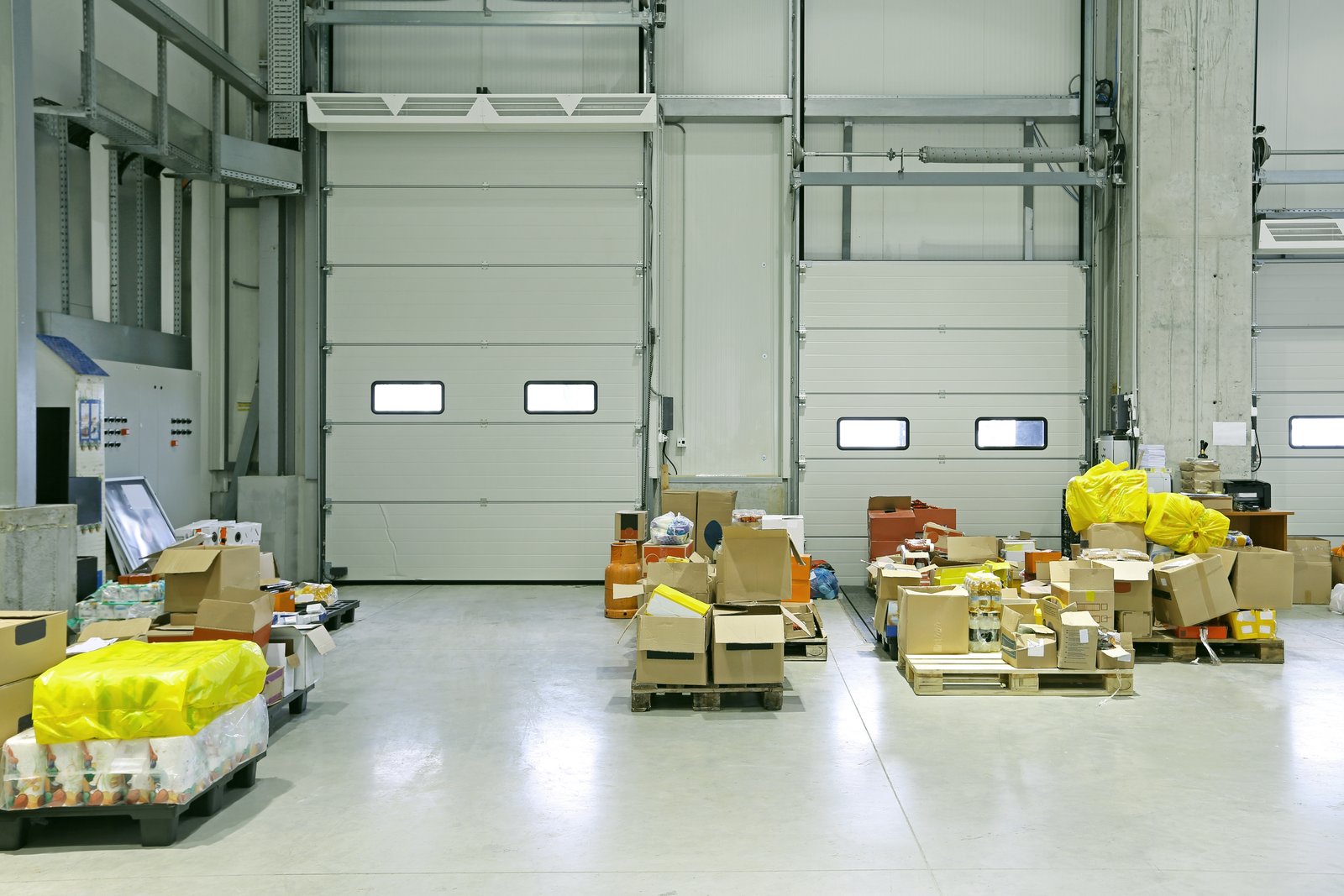 Goods left on the floor in front of closed loading doors in a distribution warehouse