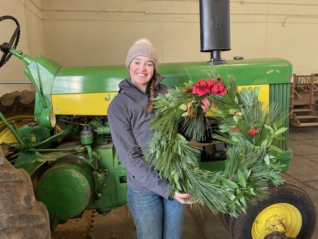 Student with holiday wreath on tractor at SRJC Shone Farm