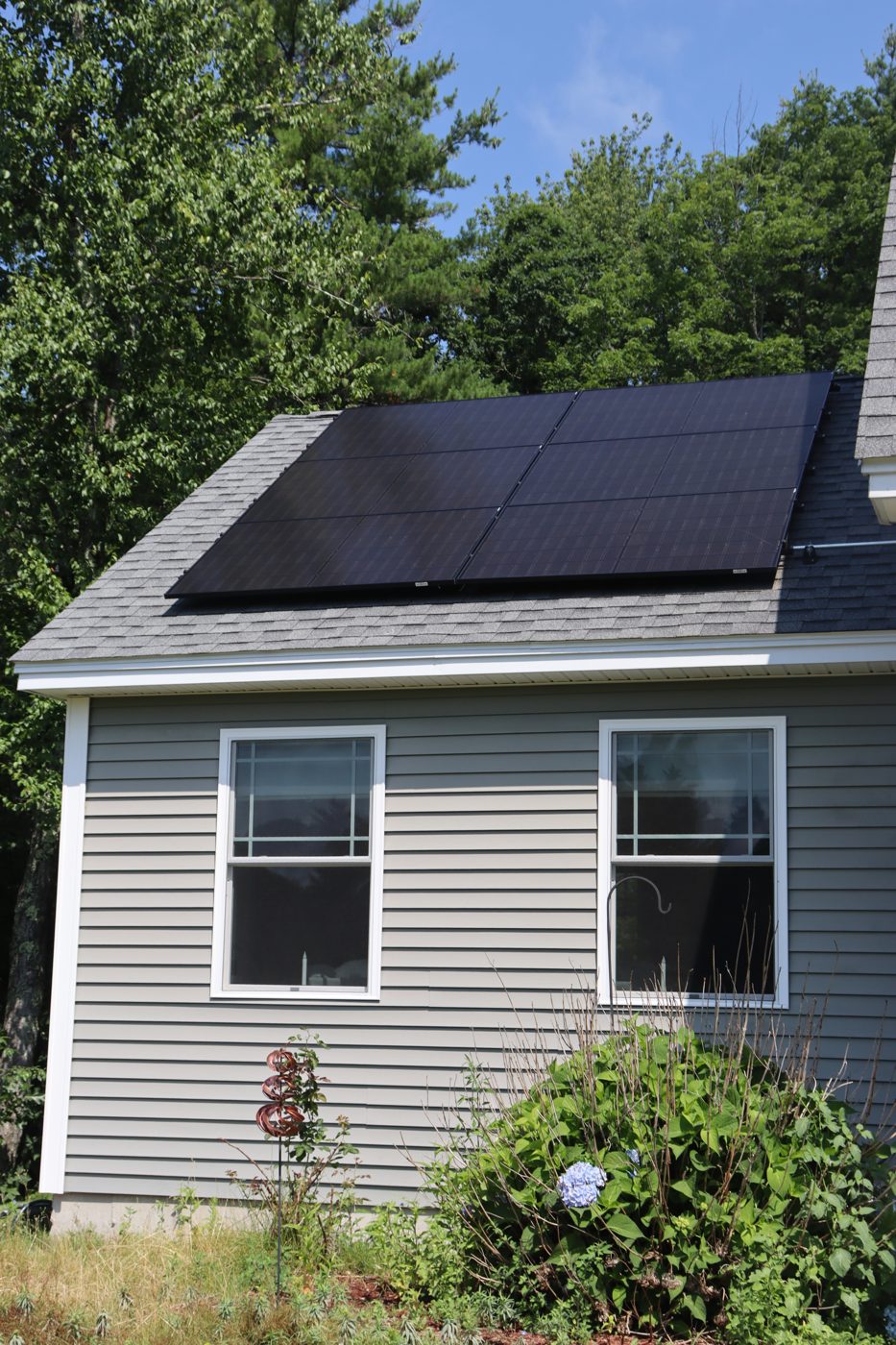 Close-up detail of black solar panels on an asphalt shingle roof