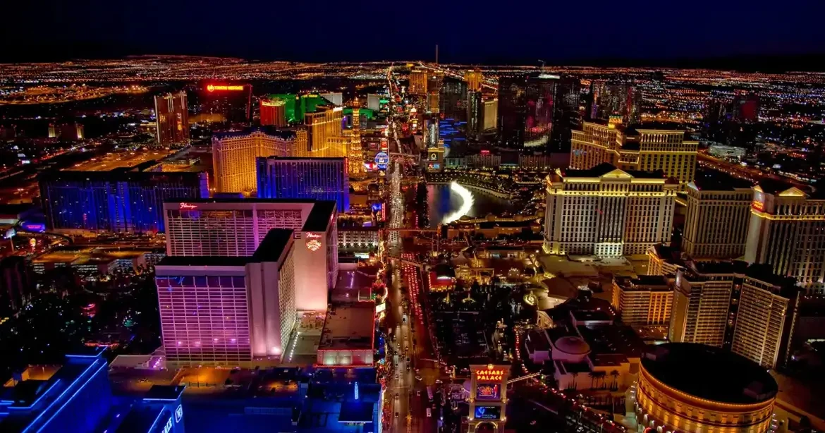 Aerial view of the Las Vegas Strip at night, showing hotel and casino towers lit up along the boulevard