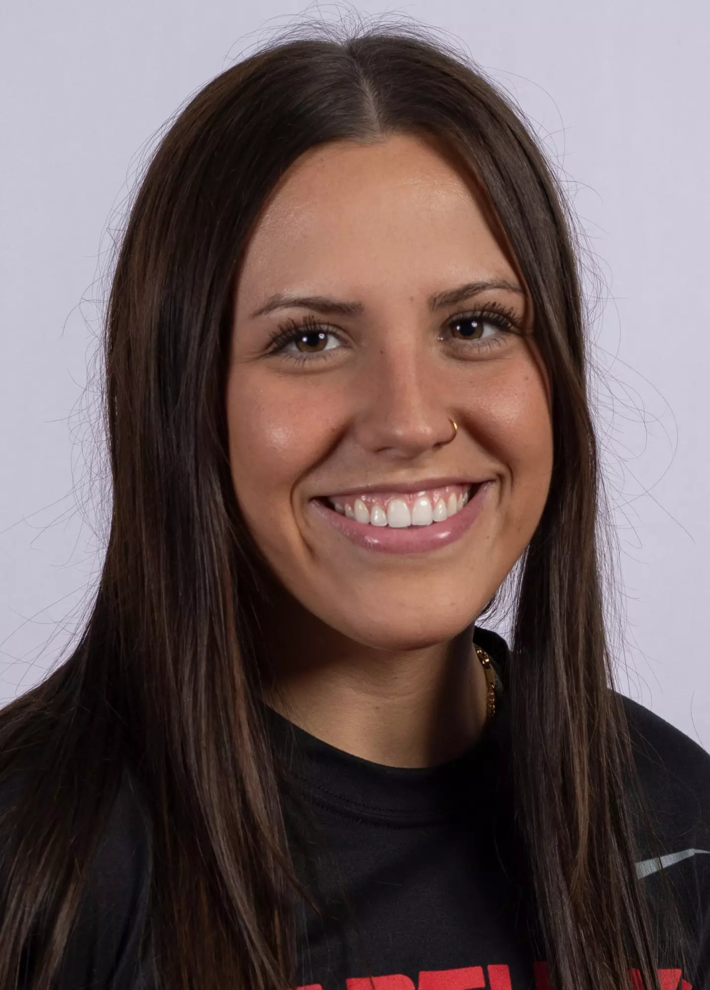 Smiling young woman with long brown hair, nose ring, and wearing a black shirt.