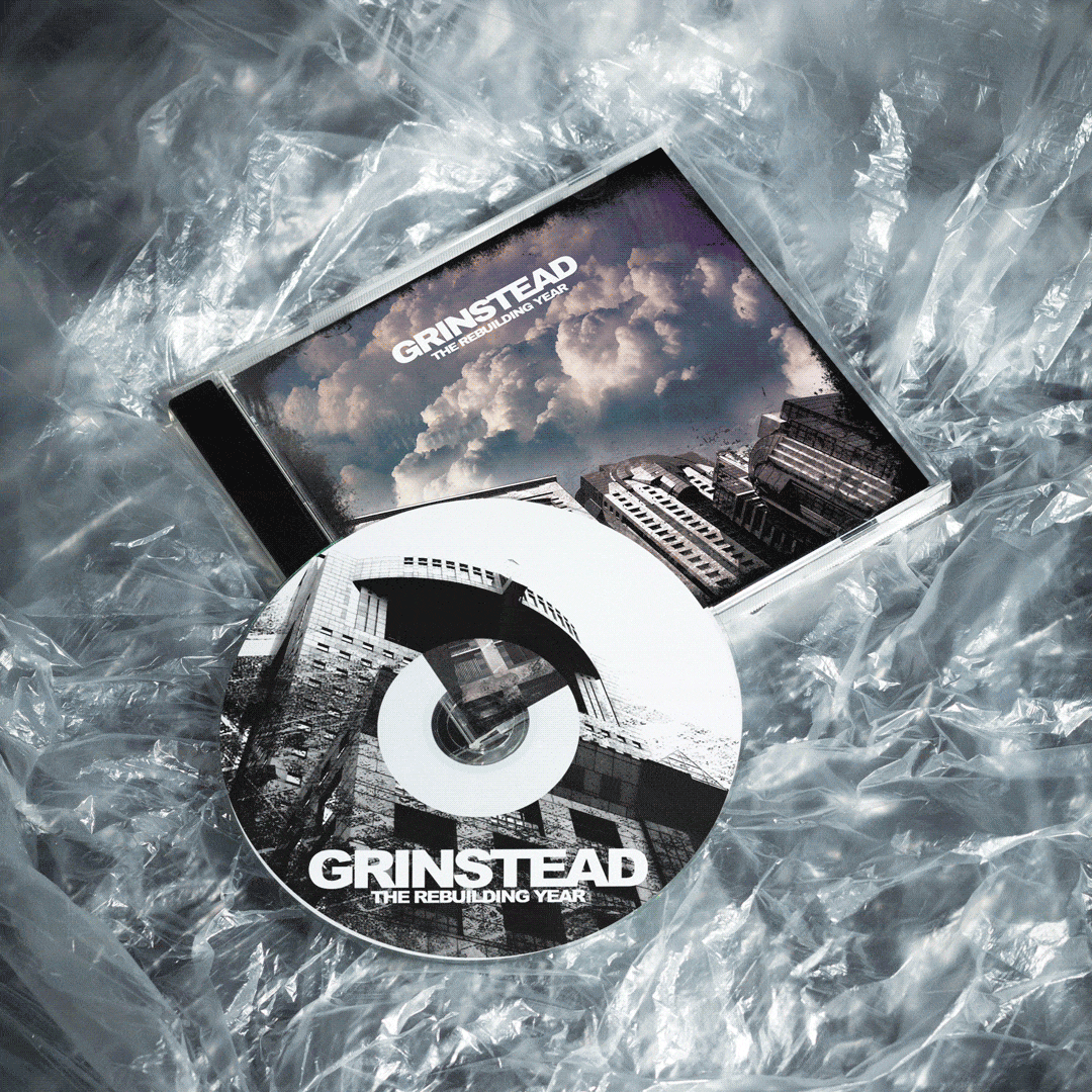 Grinstead "The Rebuilding Year" CD and jewel case mockup wrapped in plastic, featuring cloudy sky and building photography.