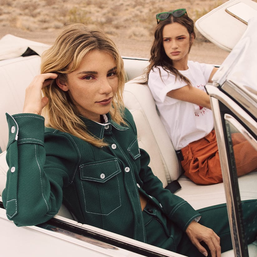 VRSNL "Summer State of Mind" campaign, art directed by Alex Mera — two models ride in a white vintage convertible against an open desert backdrop.