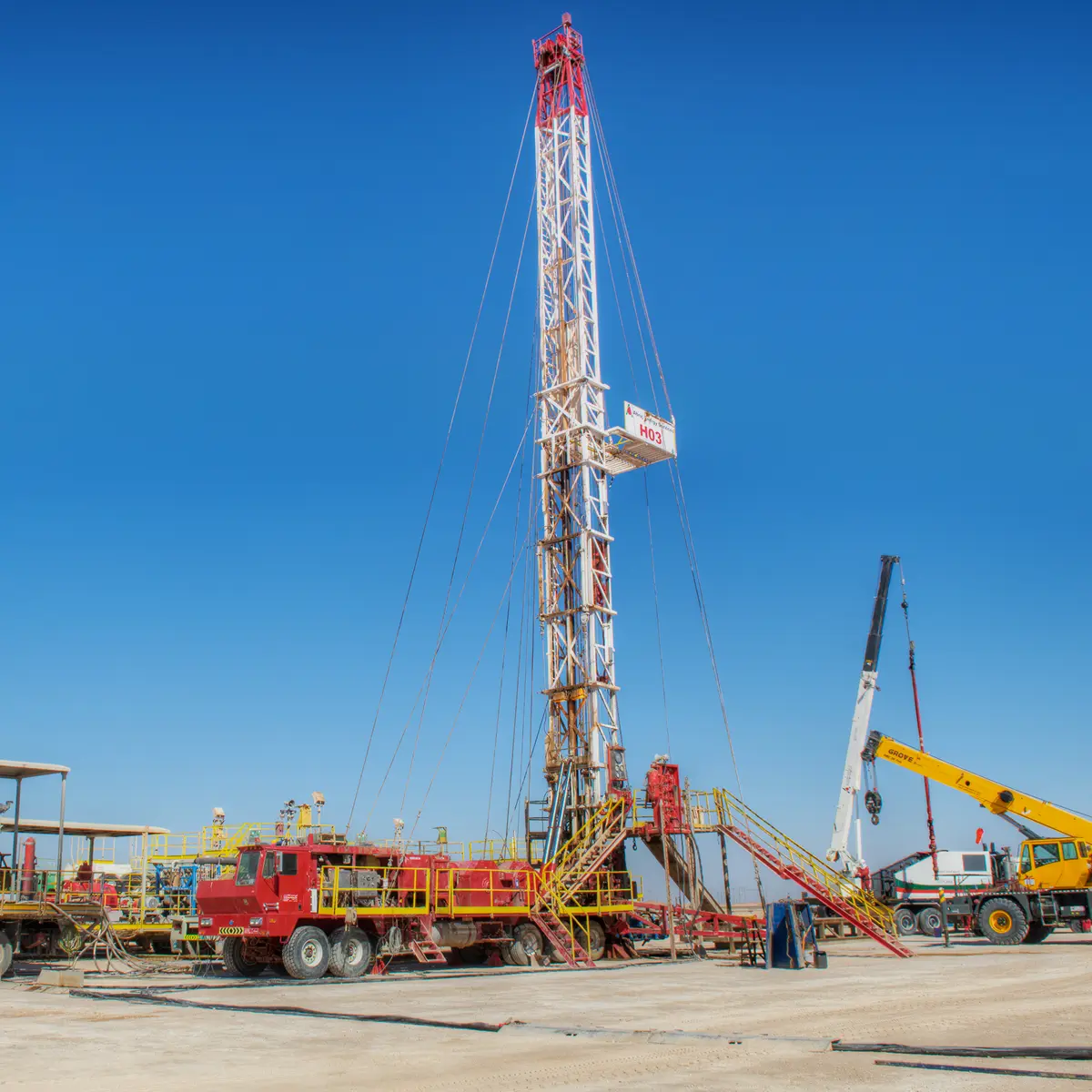 Workover rig with support cranes during operation