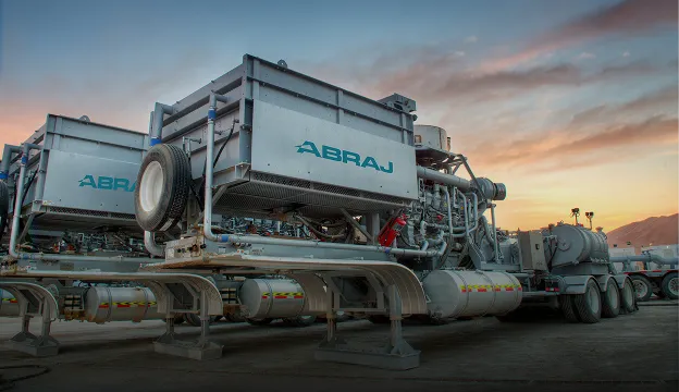 Abraj-branded field mixing units on trailers at sunset
