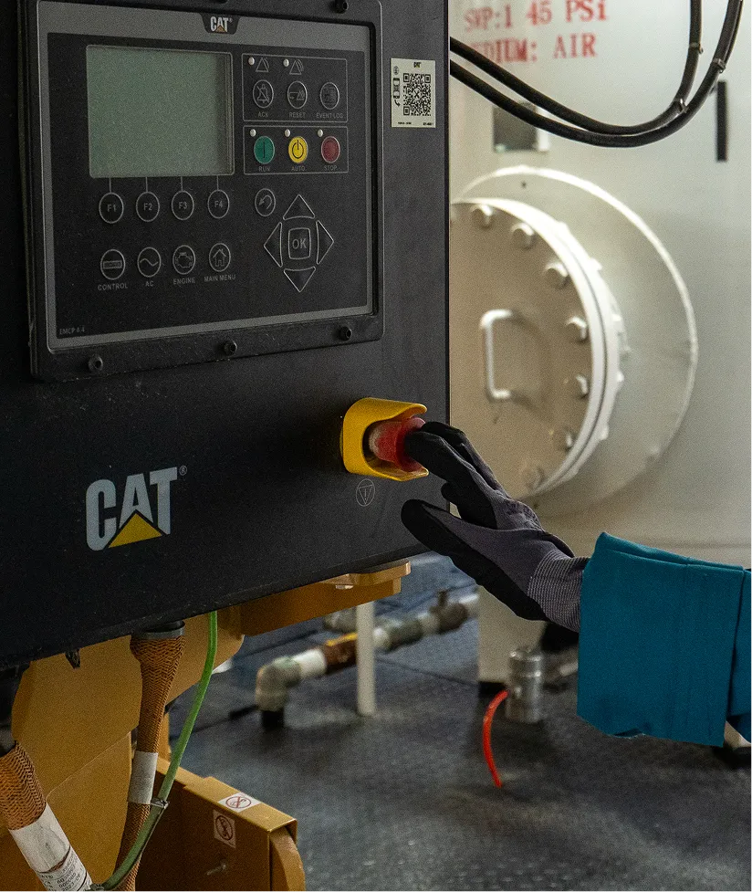 Operator using a CAT engine control panel on well equipment