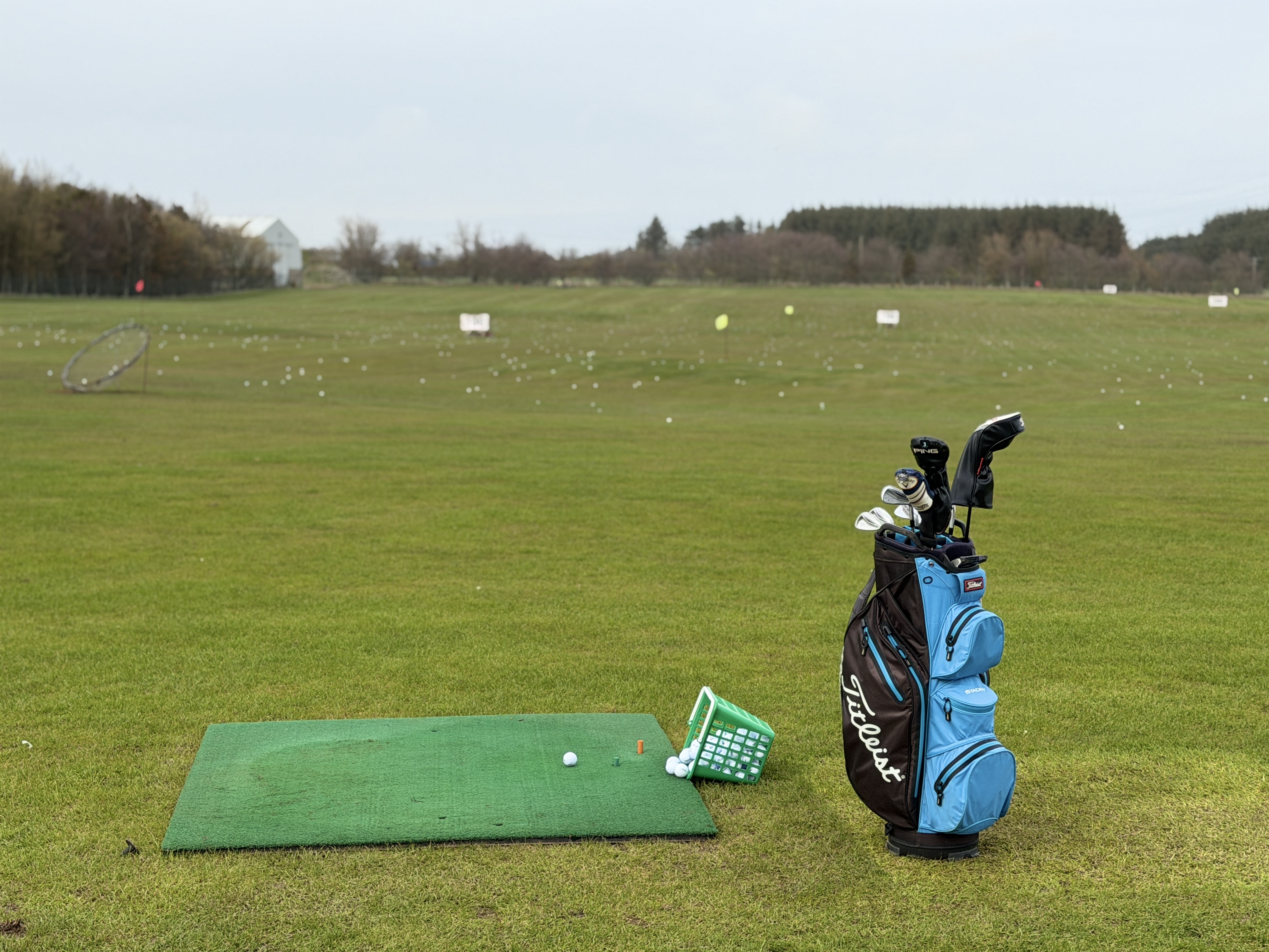 Golfer practicing on grass bay at Berryhill Driving Range Peterhead
