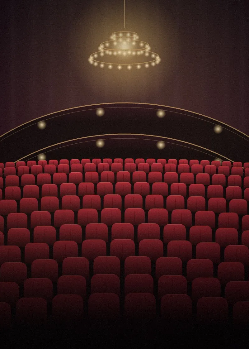 Theater auditorium with red velvet seats beneath a glowing chandelier