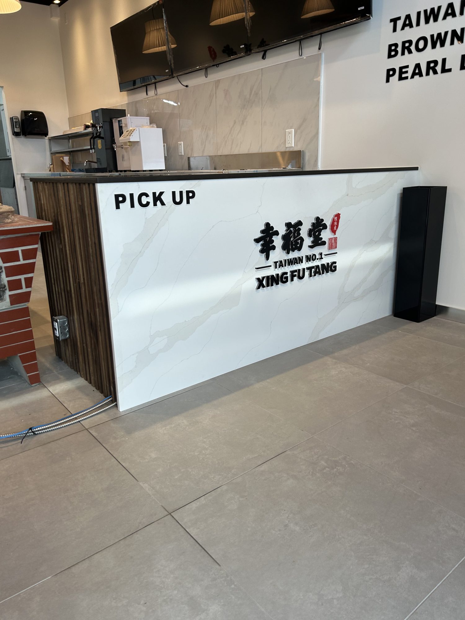 Finished pick-up counter with stone-look slab facing in a multi-unit bubble tea shop build-out in Mississauga