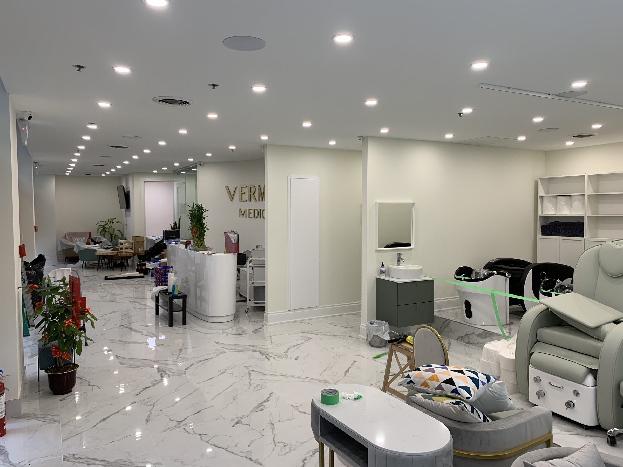 Completed medical clinic floor with polished marble tile, treatment stations and recessed lighting — commercial tenant improvement in the GTA