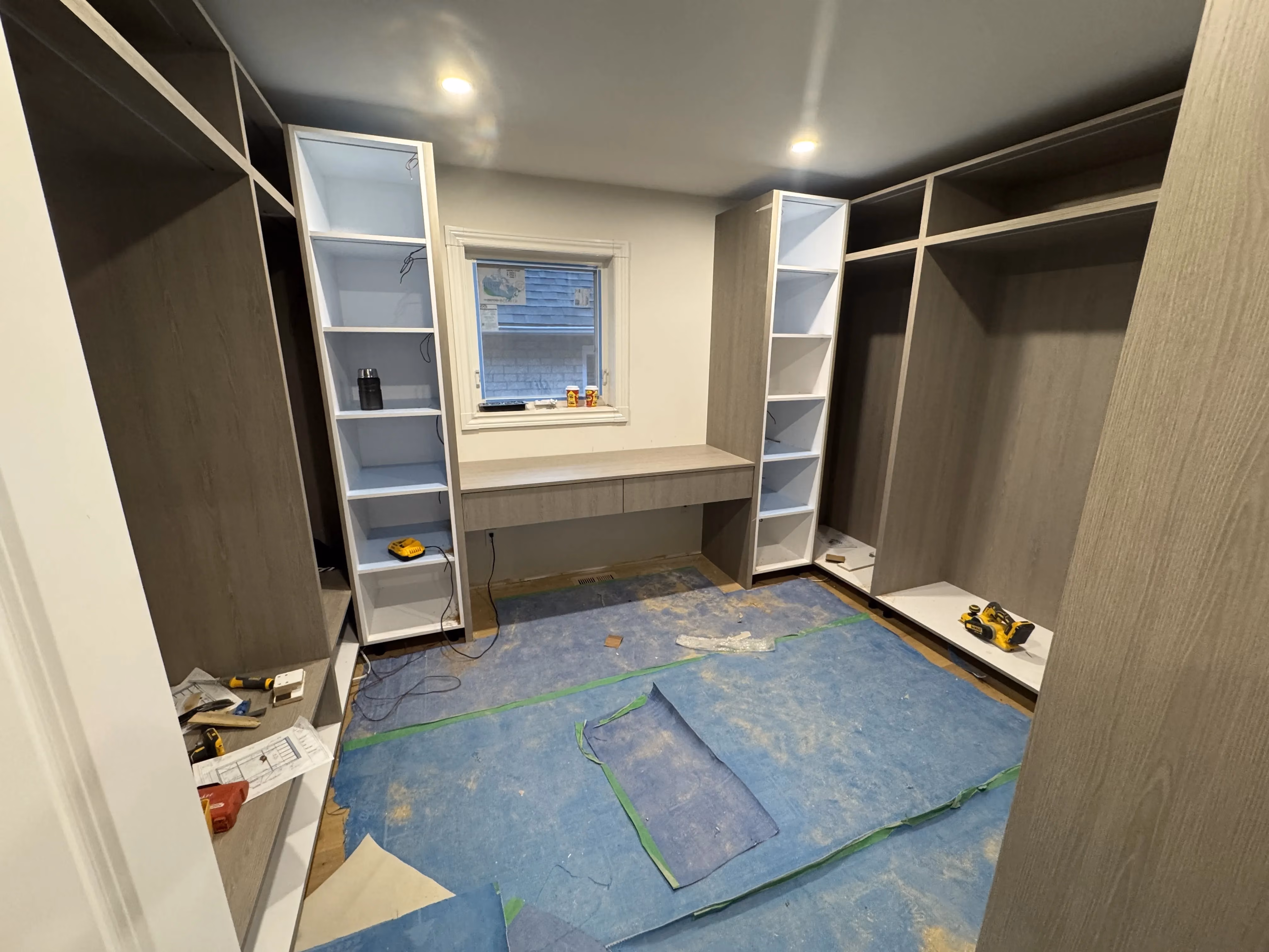 Custom wall cabinetry being installed during handover of a commercial fit-out, Toronto