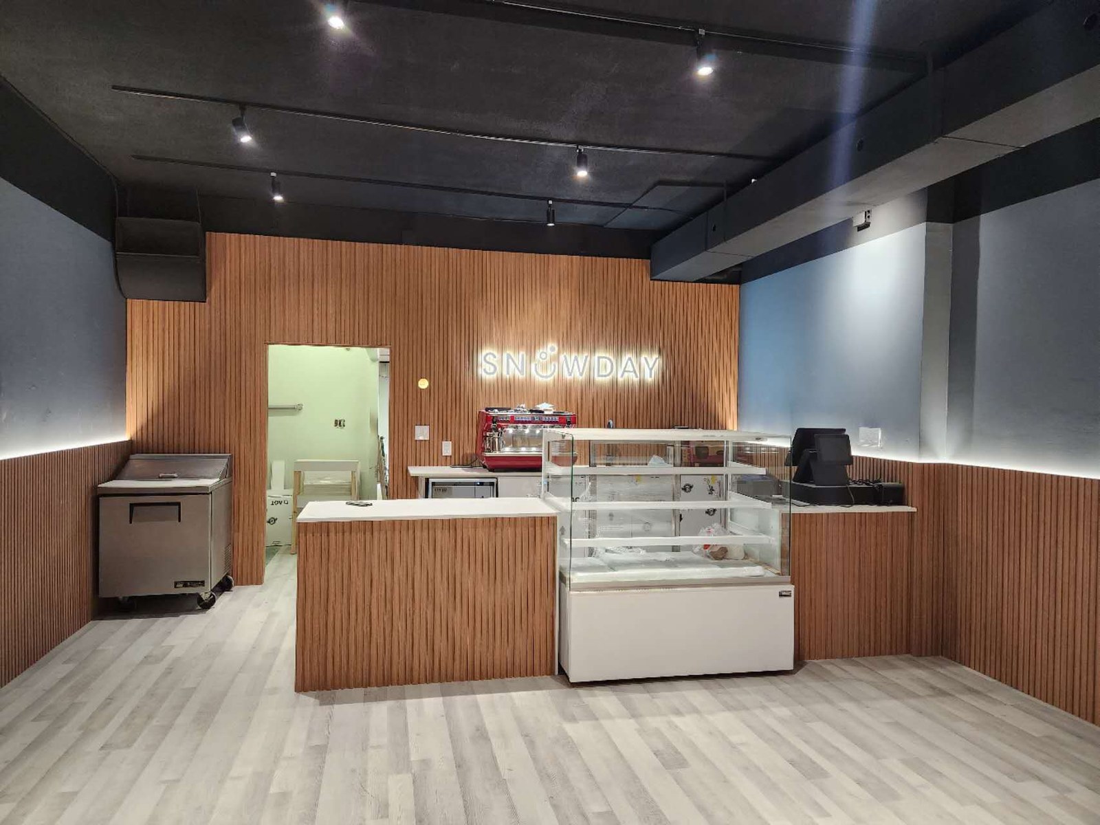 Snowday dessert cafe service counter with display fridge and neon sign after renovation in Toronto