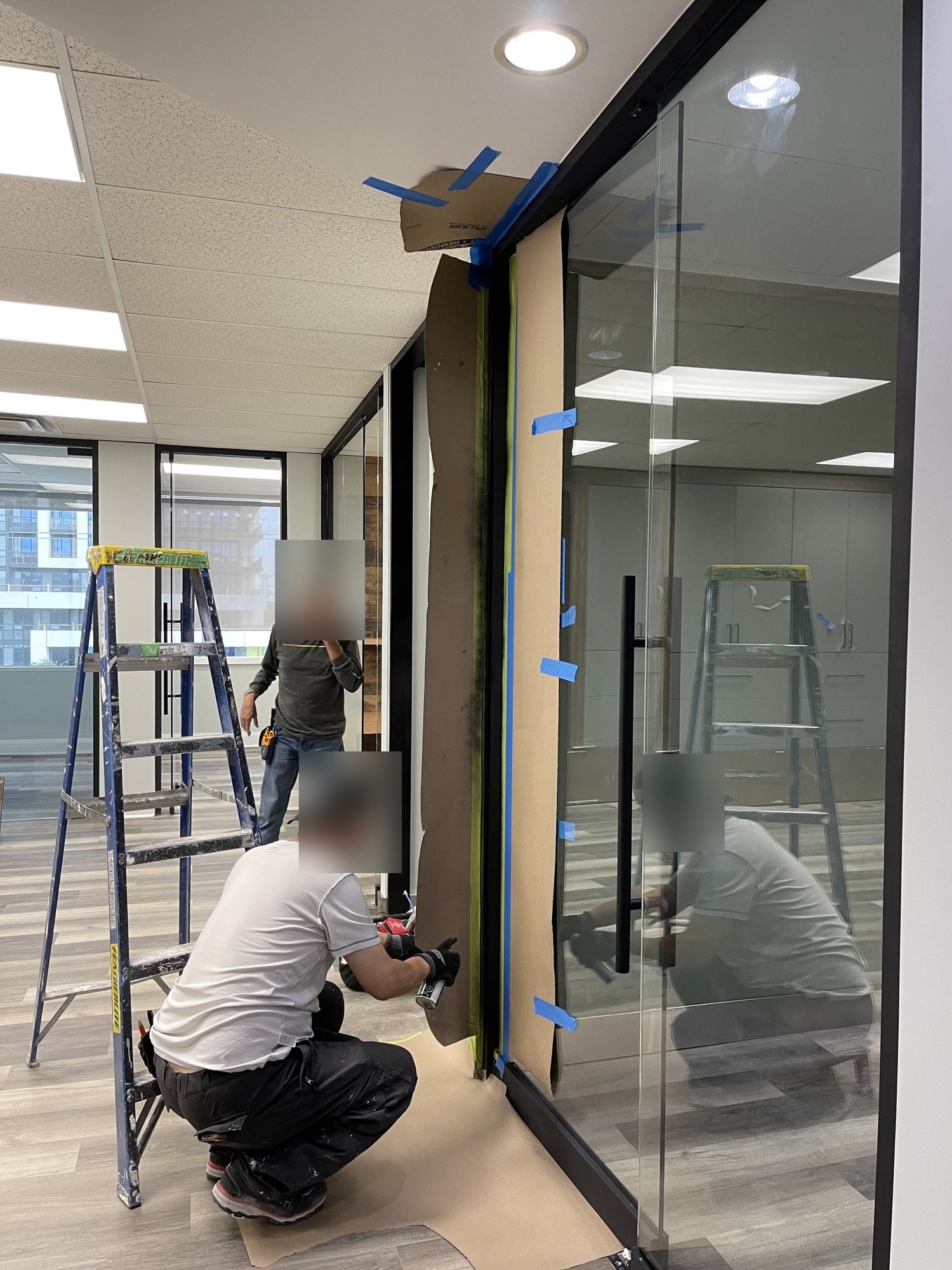 Buildup Contracting crew installing a full-height glass office partition during a Richmond Hill office fit-out