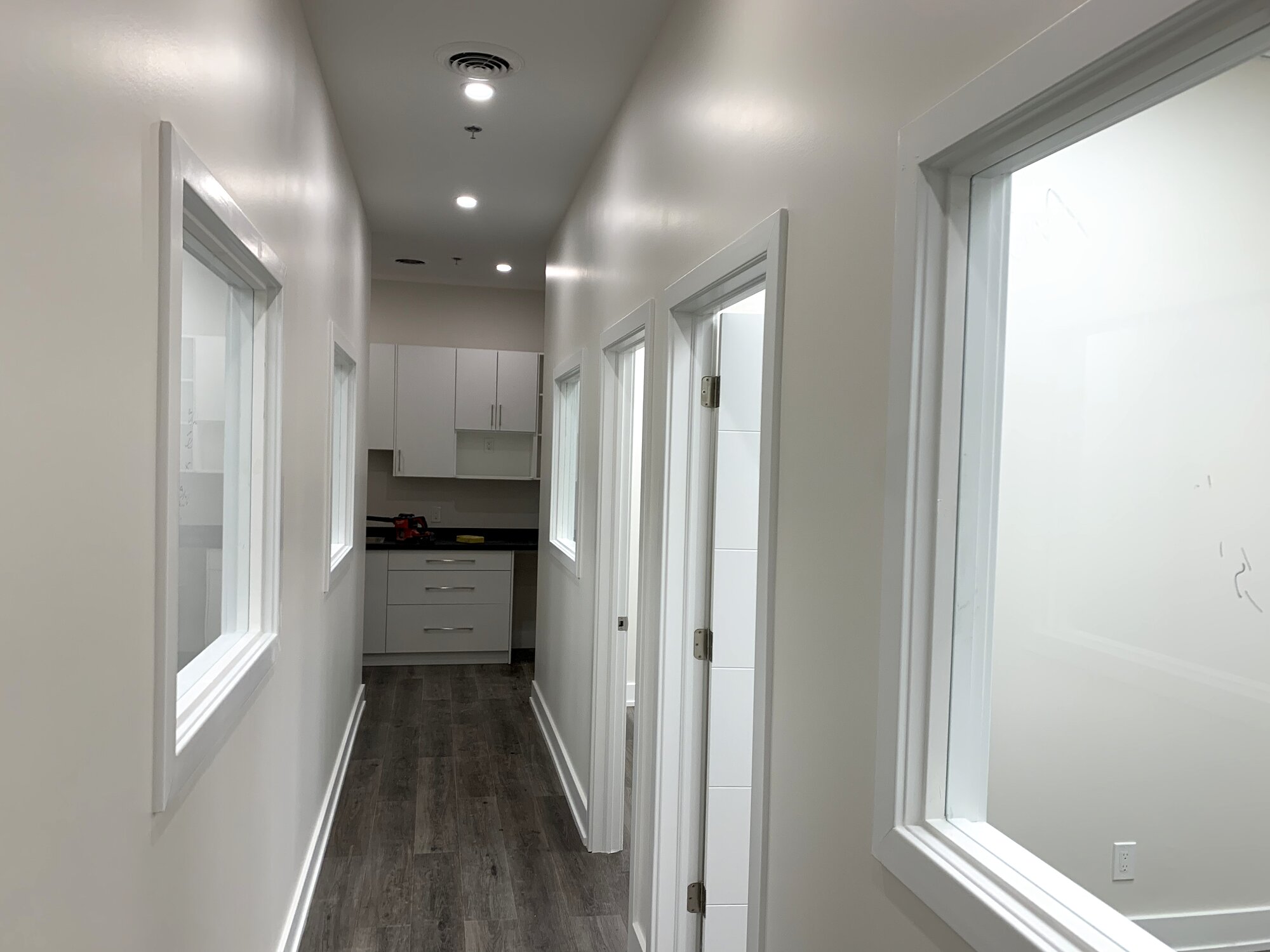 Bright office corridor with interior windows carrying daylight through a completed Richmond Hill office fit-out