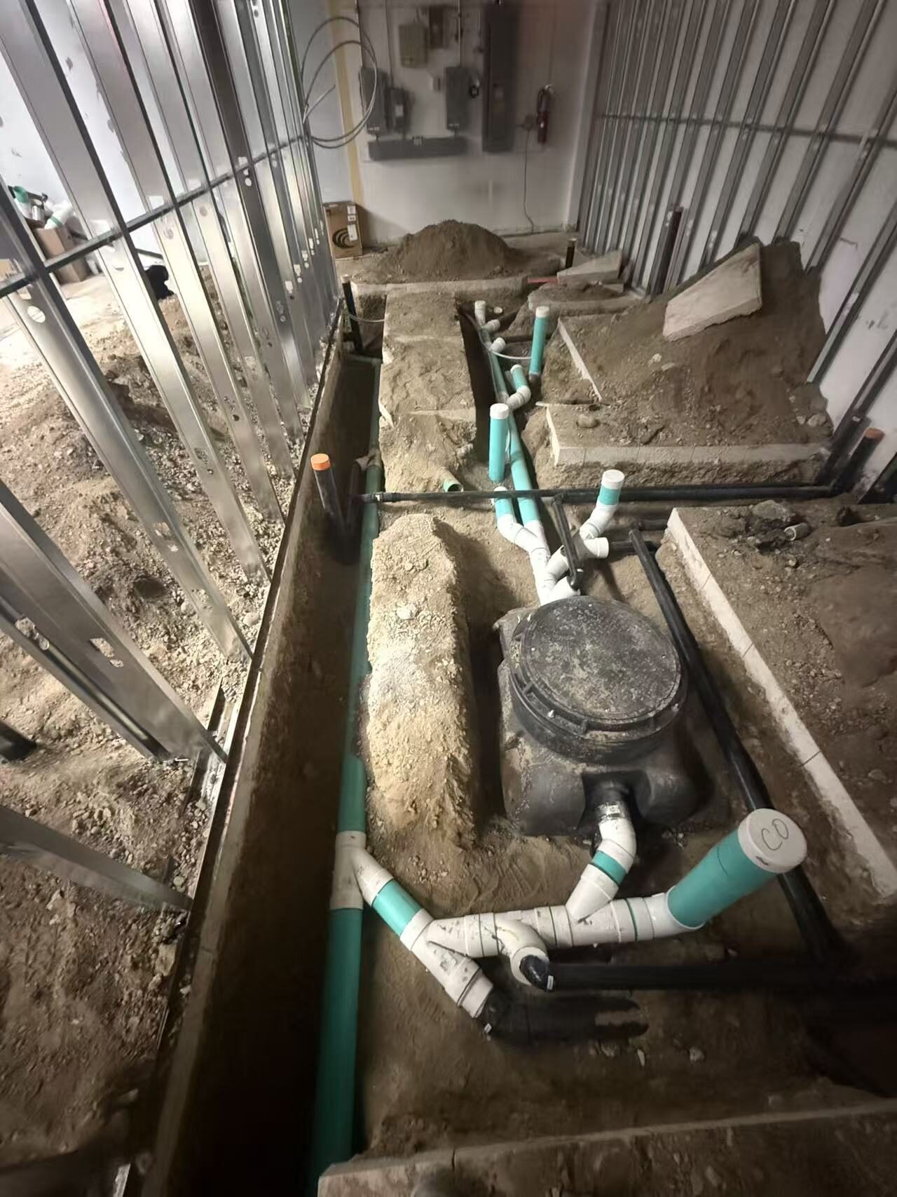 Under-slab sanitary and grease waste plumbing rough-in for a Toronto quick-service restaurant