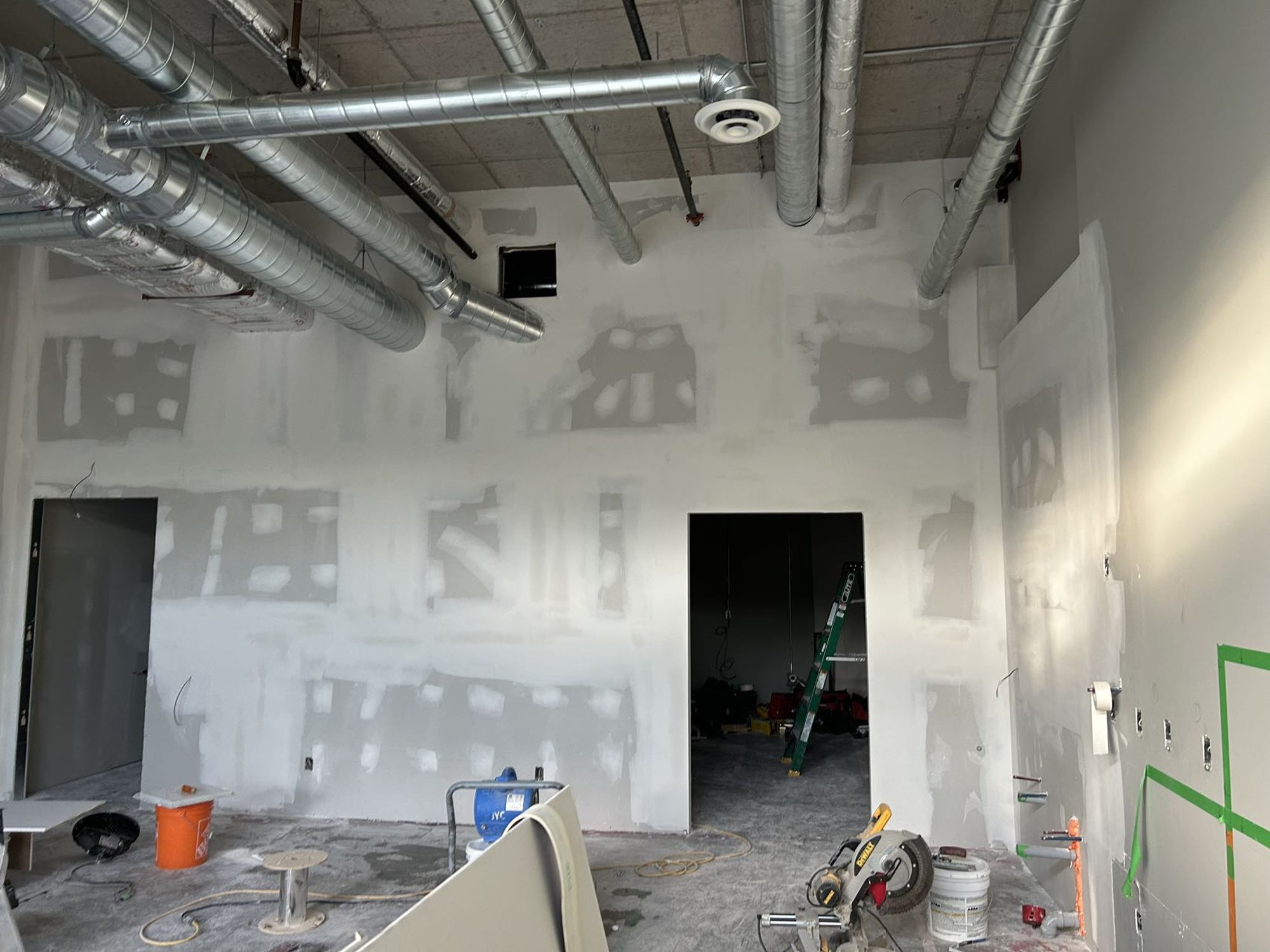 Drywall and taping complete on the partition walls of a bubble tea shop build-out in Mississauga