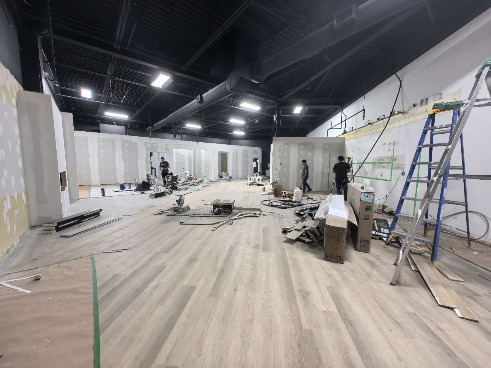 Luxury vinyl plank flooring being installed across a 4,000 sf showroom floor