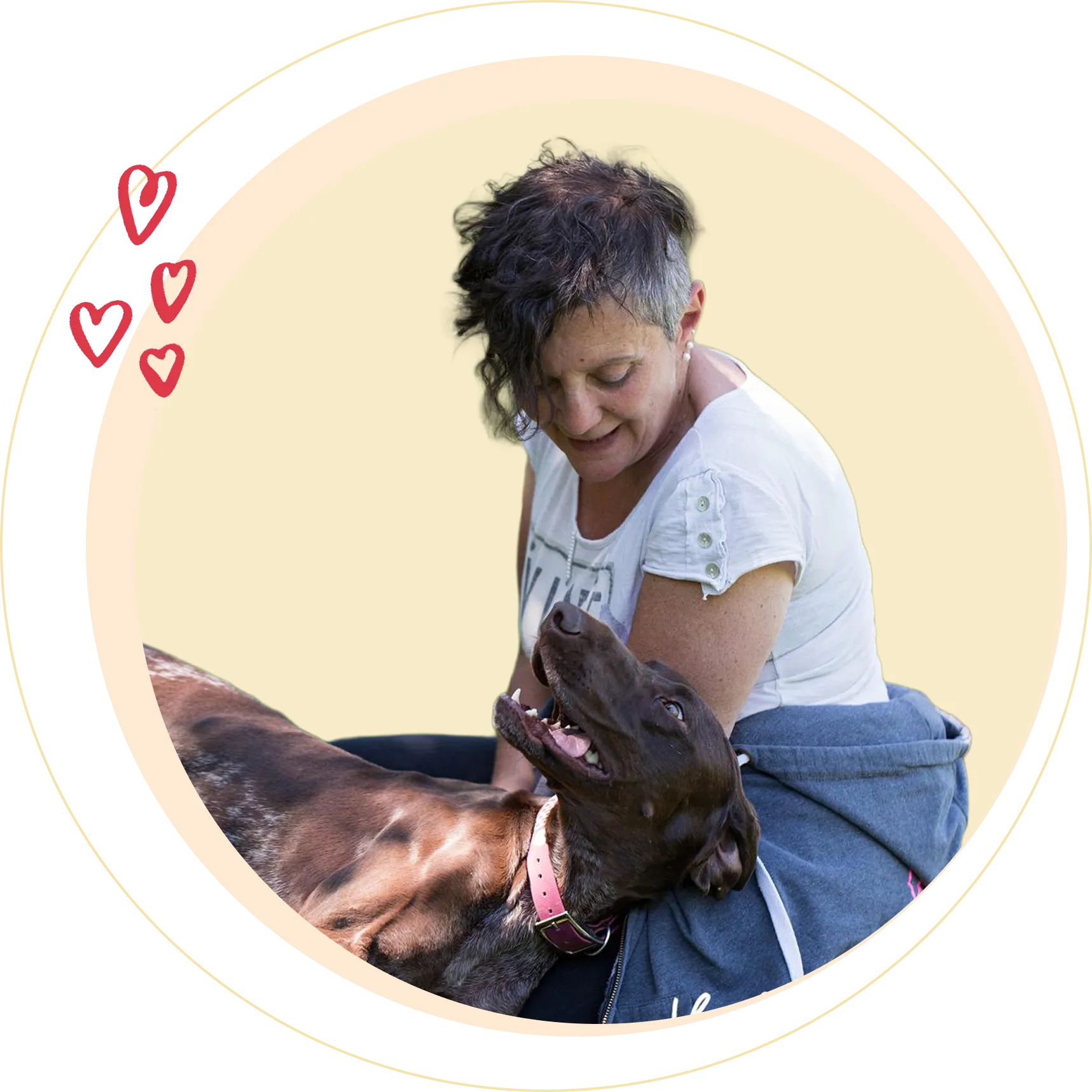 Woman in a white shirt sitting and looking lovingly at a happy brown dog laying on her lap inside a circular frame with drawn red hearts.