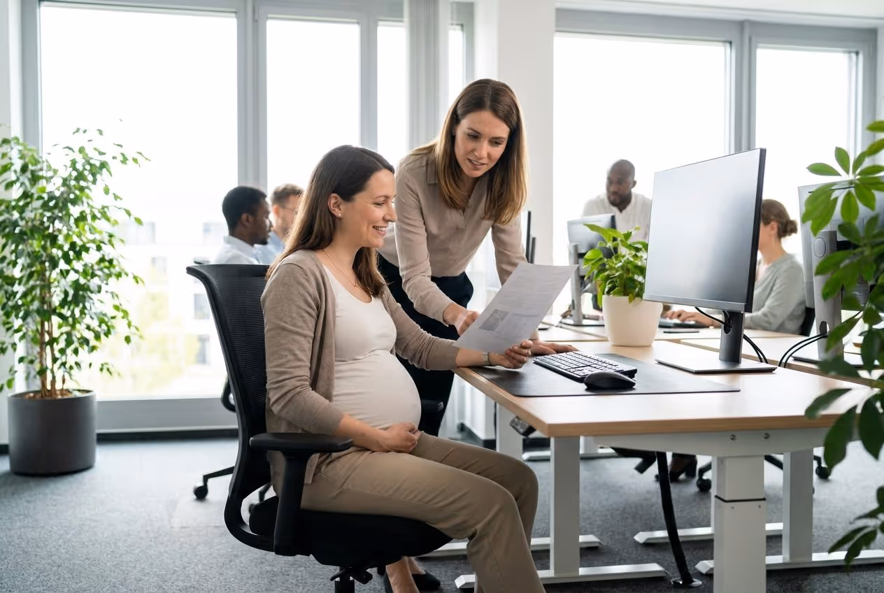 Schwangere Mitarbeiterin am ergonomischen Arbeitsplatz