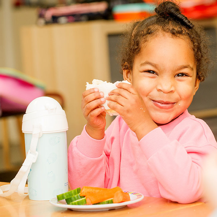 Smiling child enjoying her lunch