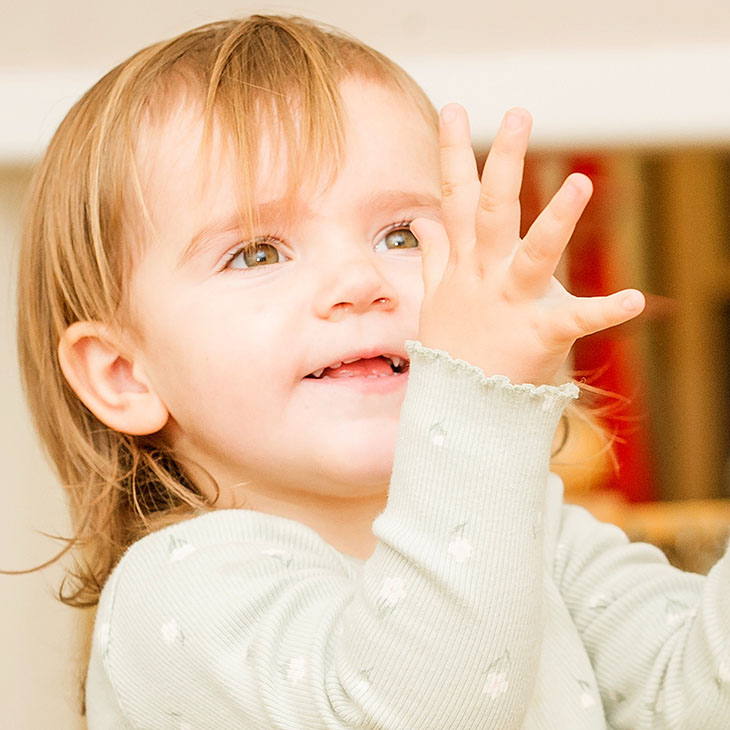 Toddler with hands outstretched to catch a ball