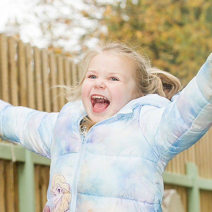 Happy girl with arms outstretched outside