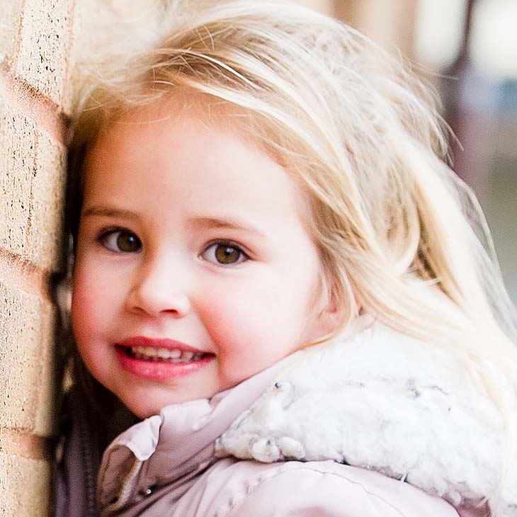 Smiling girl on against the climbing wall