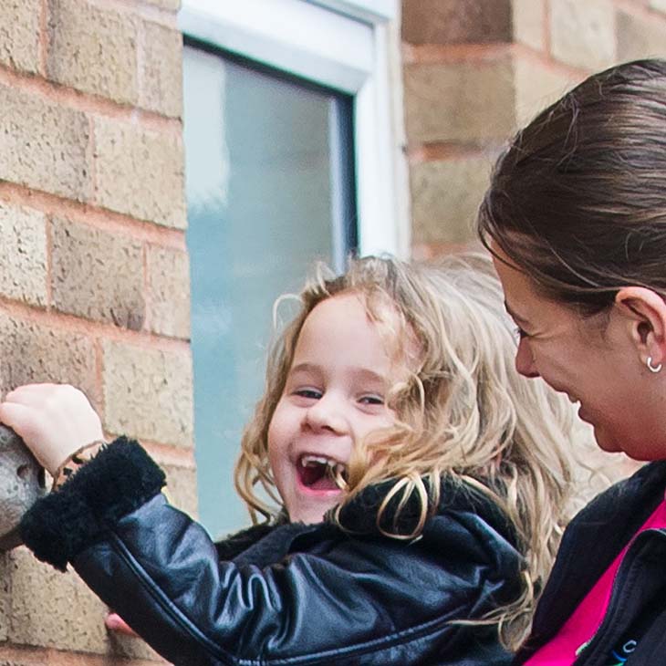 Little smiling girl being helped to climb