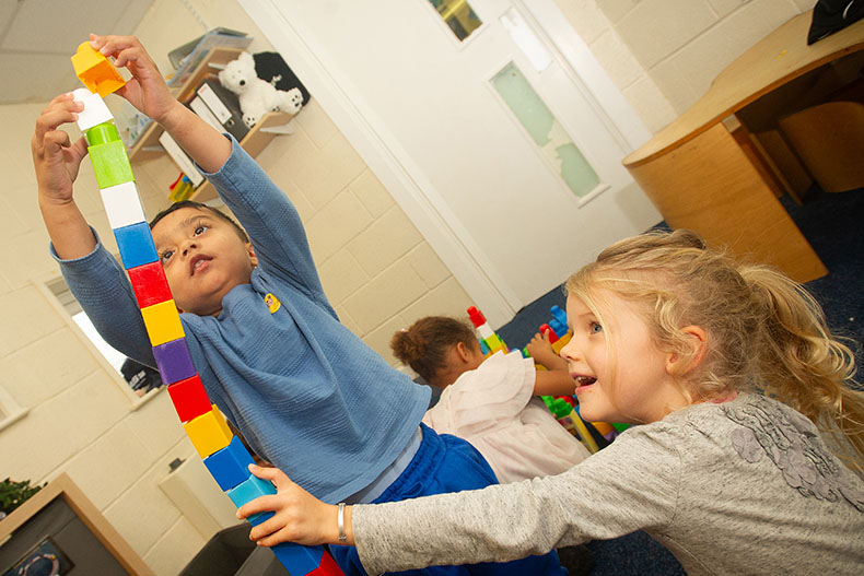 Boy and girl building a huge brick tower
