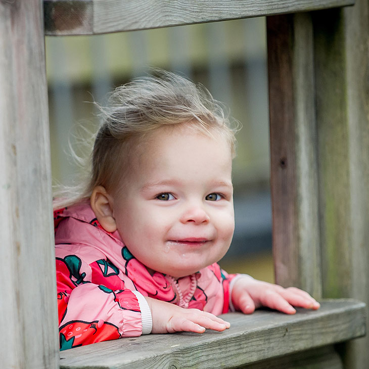 Child looking out of a wooden play house
