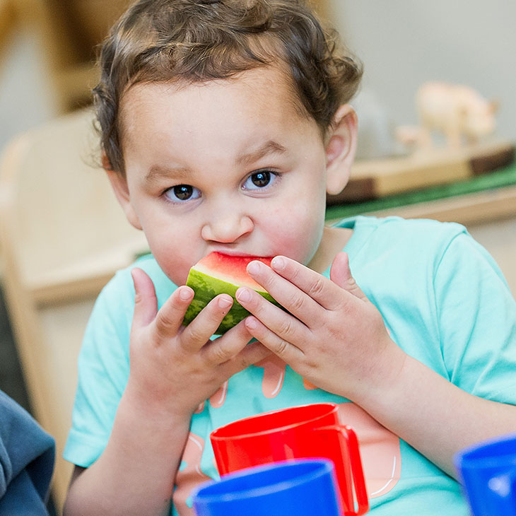 Child eating a piece of watermelon 