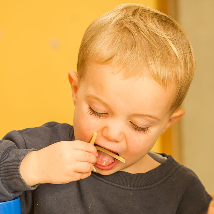 Little boy eating with his hands