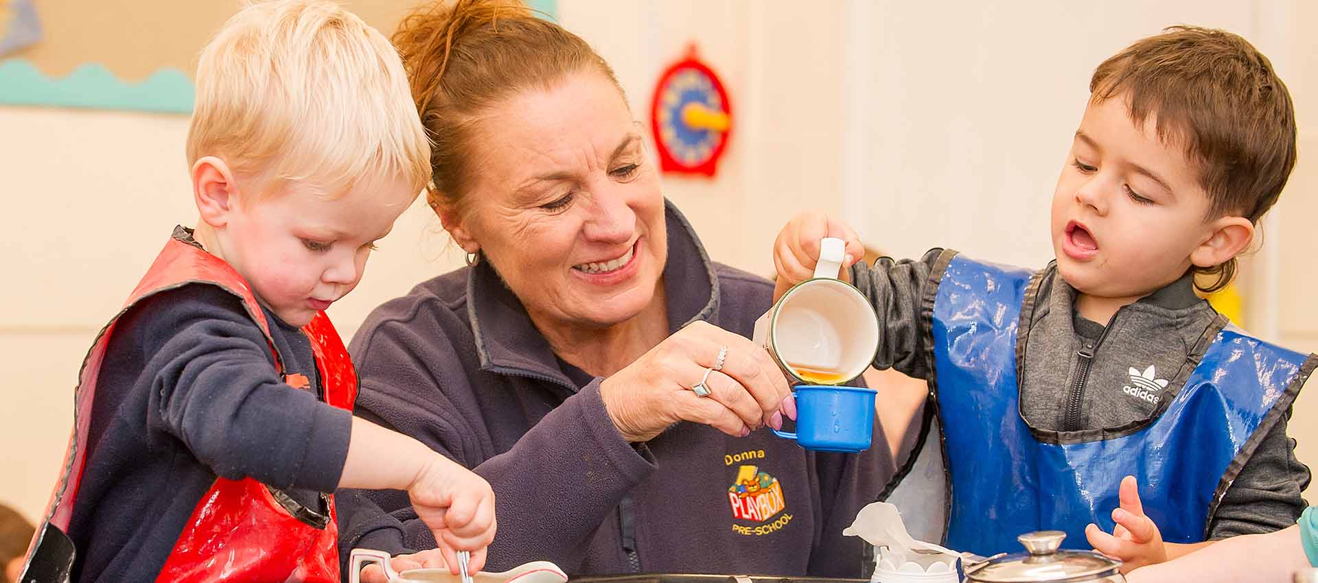 Teacher playing tea parties with children