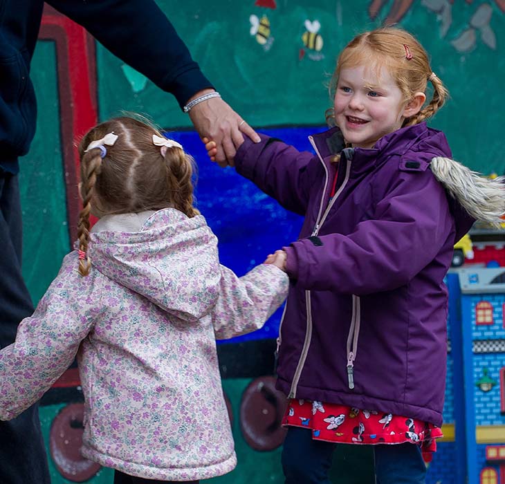Girls holding hands with a teacher