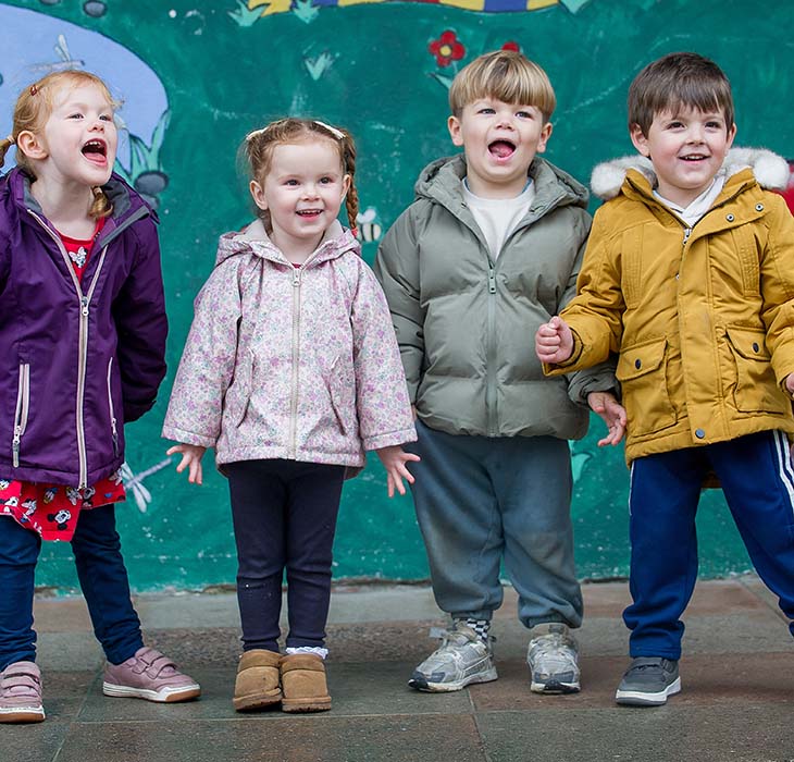 4 children holding hands in the playground