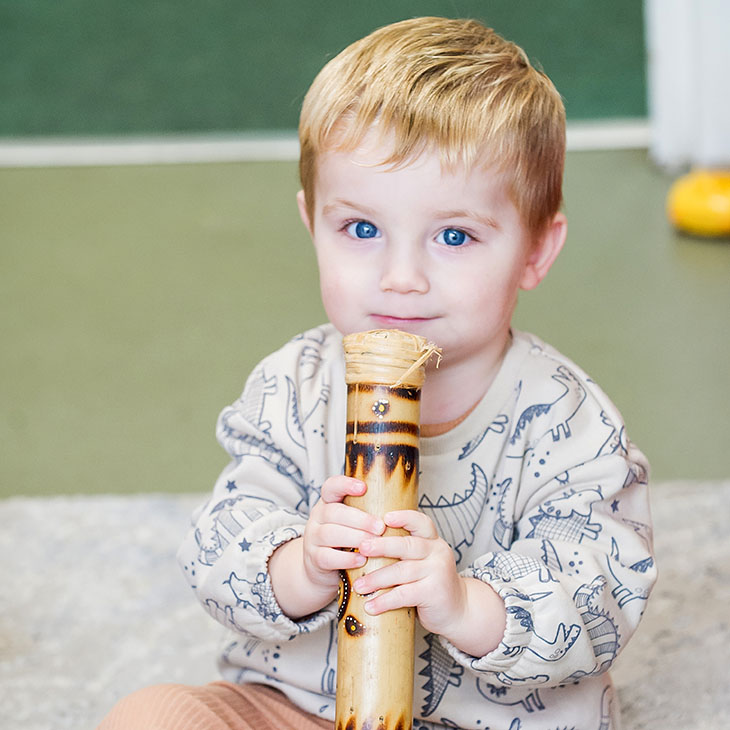 Little boy clutching a musical instrument 