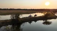 Sunset reflections around a pair of riders.