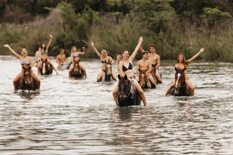 Horses and riders cooling off in the water