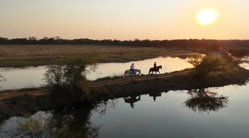 Sunset reflections around a pair of riders.