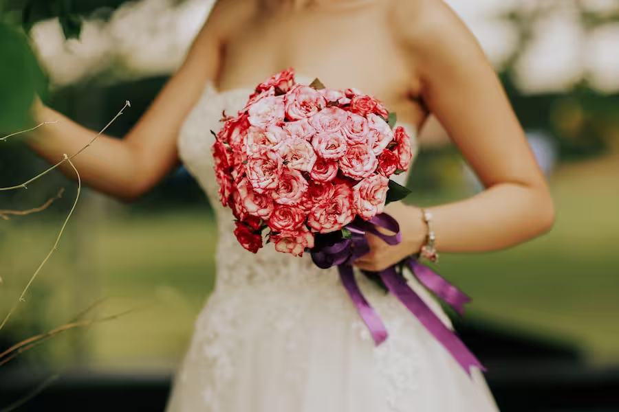 women in a wedding dress holding bouquet of flowers
