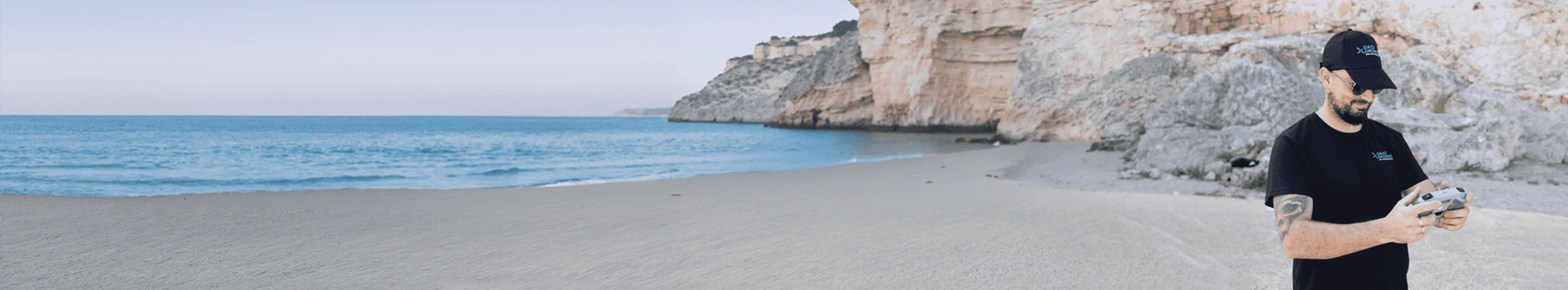 Dazz Drones pilot operating a drone on a scenic beach for travel photography