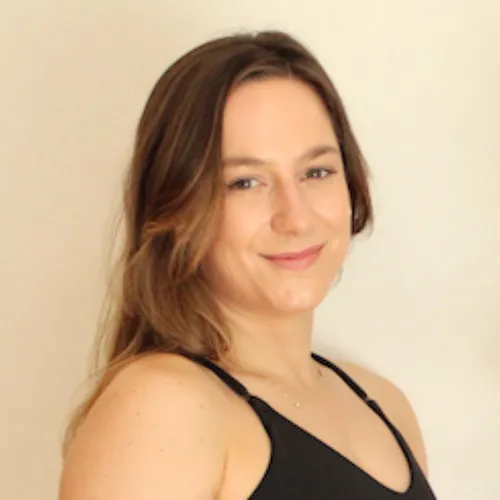 Fauve Martins, smiling woman with long light brown hair wearing a black sleeveless top against a neutral background.