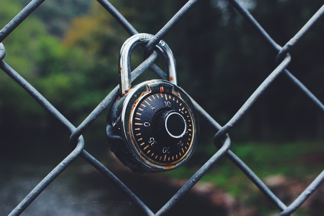 Padlock on chain-link fence representing cybersecurity protection