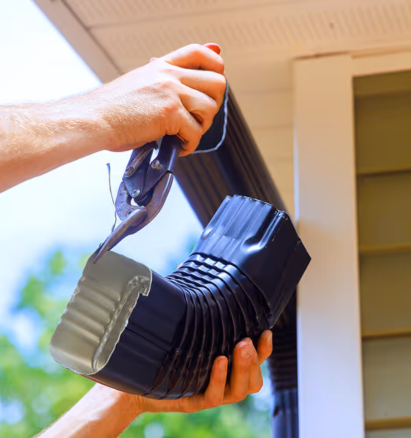 Expert gutter repair service fixing a leaking and sagging gutter system on a roofline.