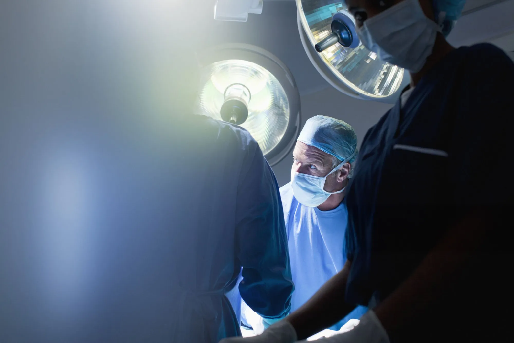 A group of doctors standing around a patient.