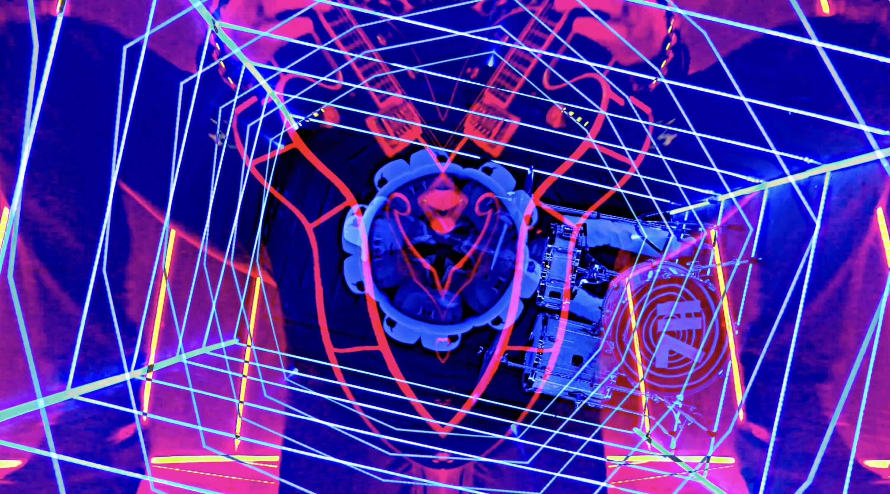 Neon colored mirrored image of man on knees playing guitar still image from music video