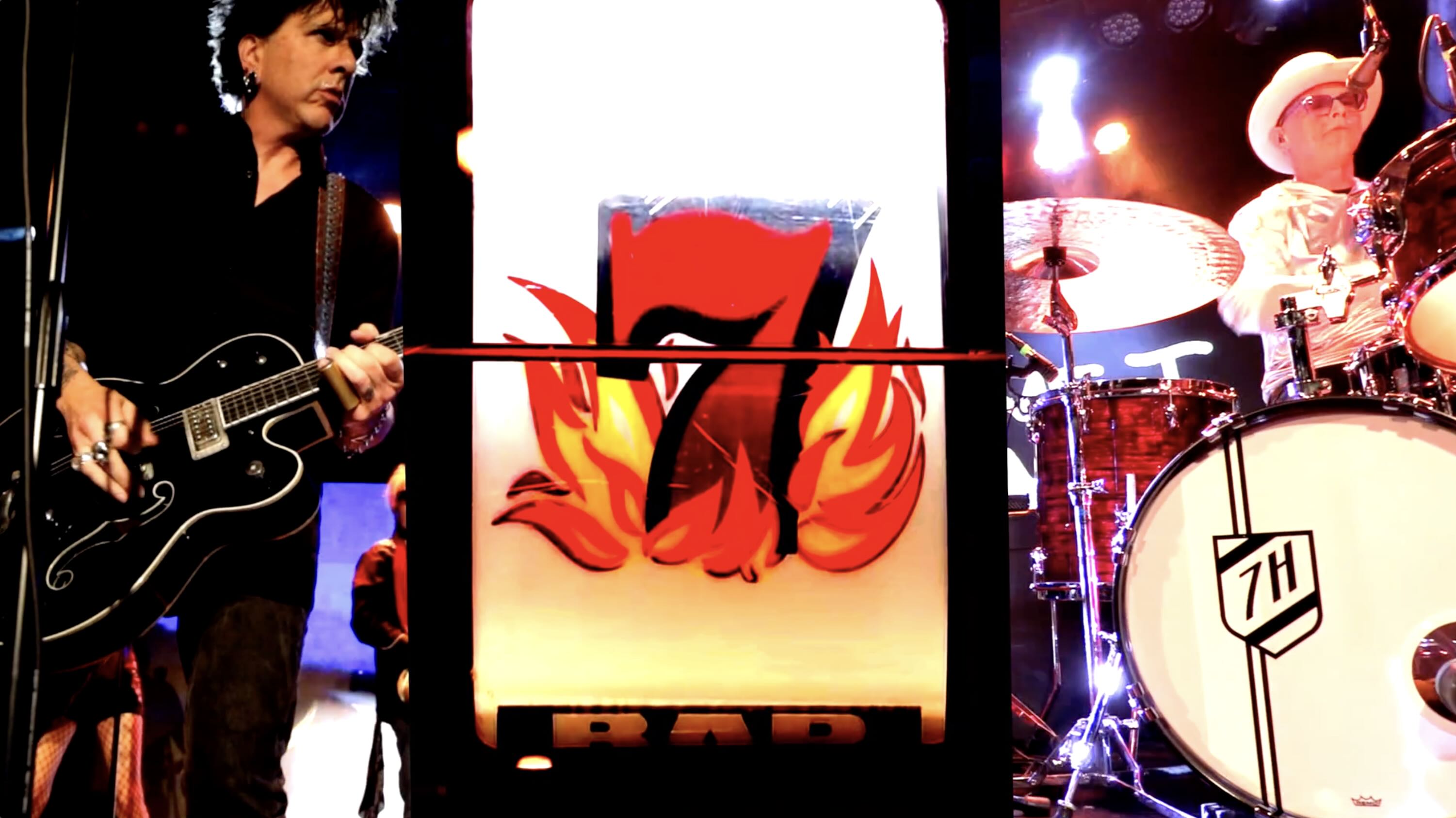 Triptych still from performance video two members of the band on either side large number seven from slot machine in between
